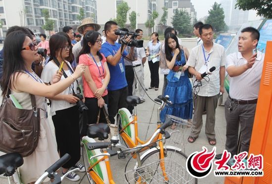 西線采訪團采訪了薛城區(qū)城市公共自行車服務系統，工作人員向記者們講解公共自行車的詳細情況。 記者 郭豪 攝。